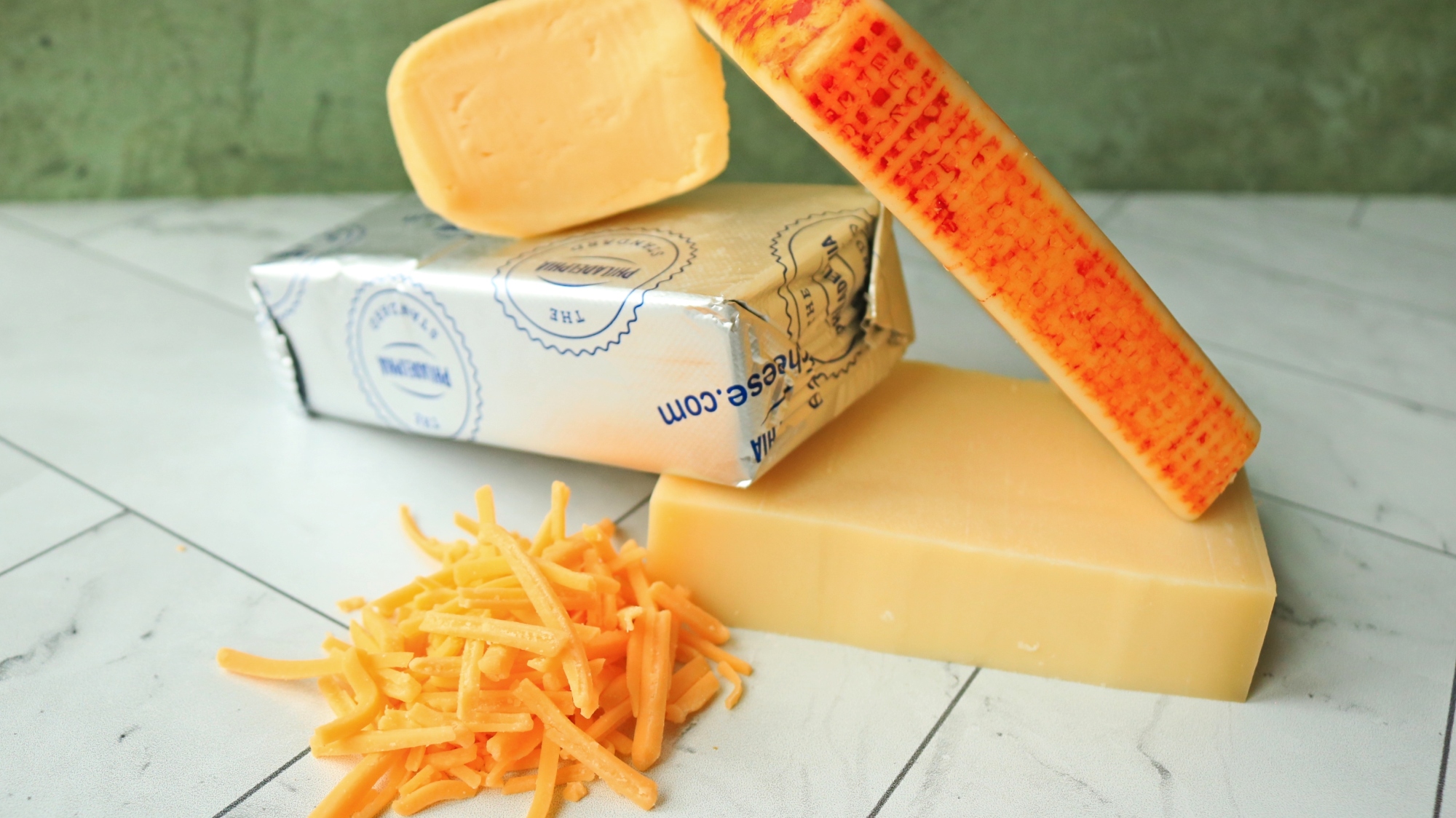 Assorted cheeses piled up on a countertop.