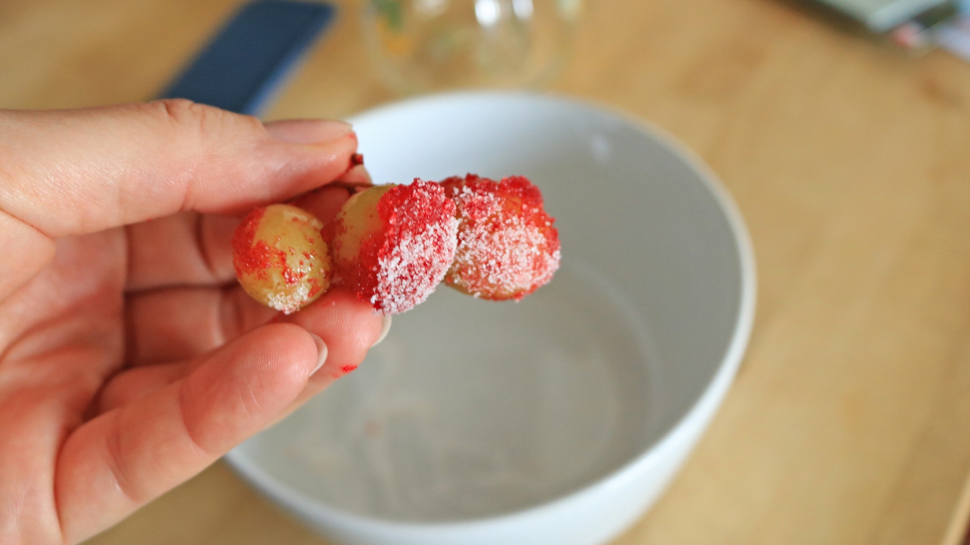 Hand holding Jell-O powdered grapes with citric acid.