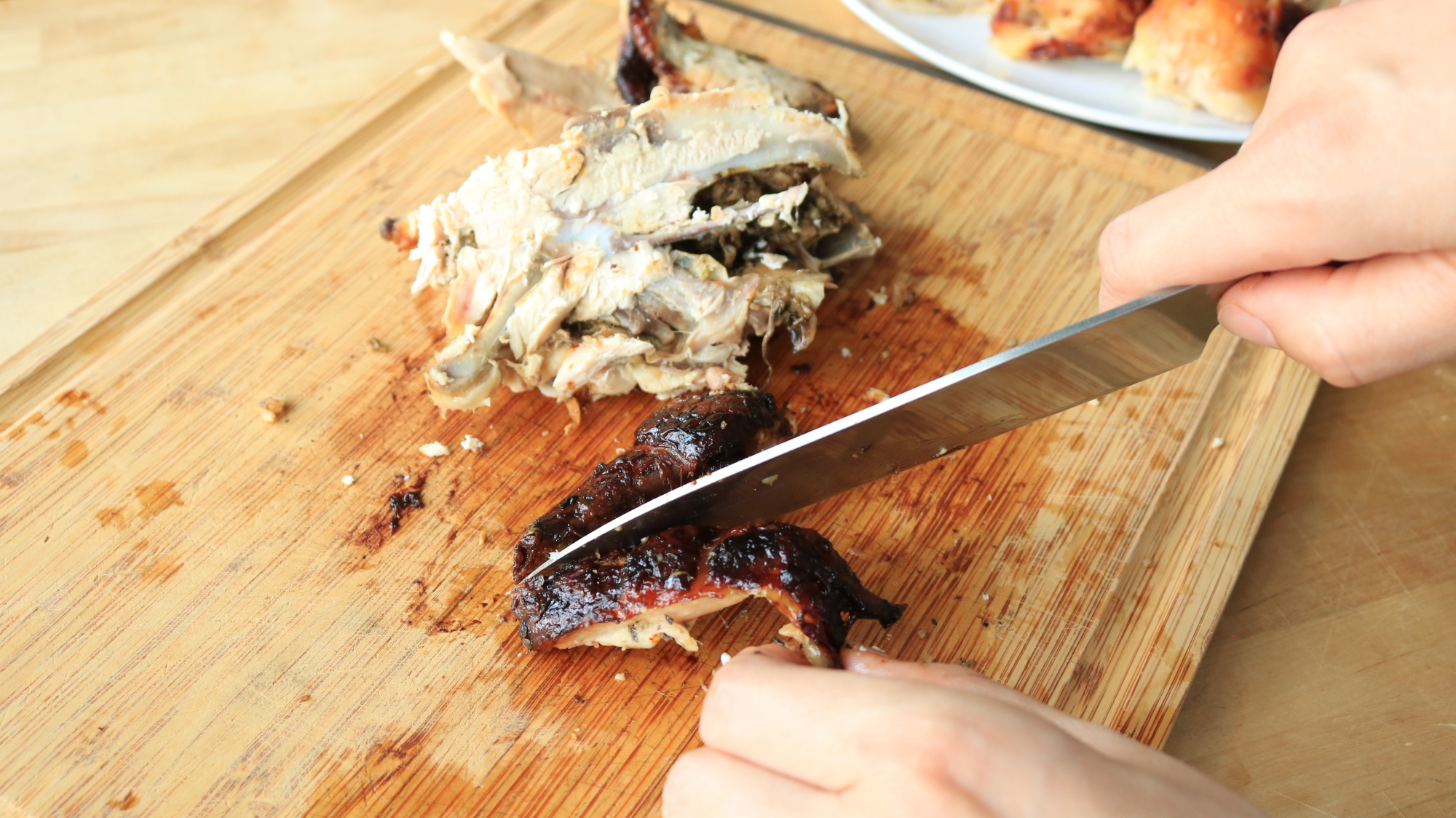 A knife cutting a chicken wing.