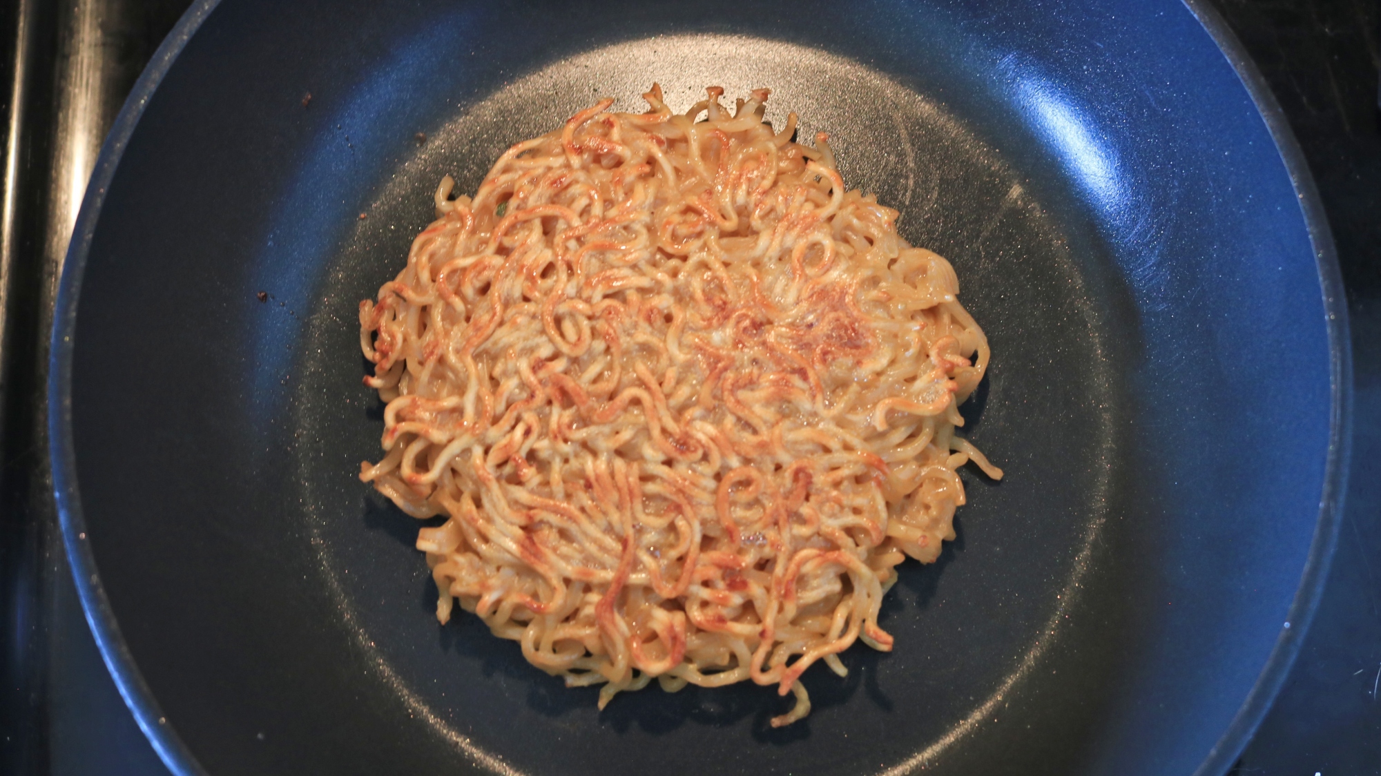 A ramen noodle patty in a frying pan.