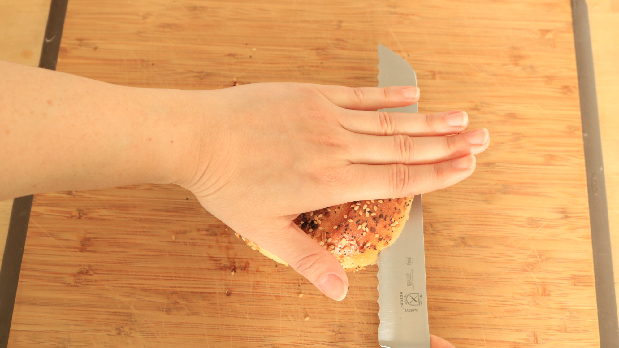 Hand holding bagel, top view