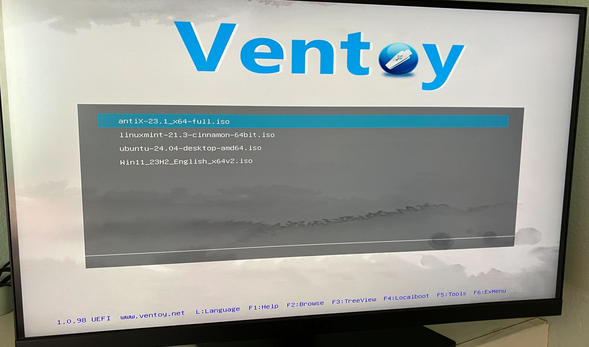 A terrible cell phone photo of my computer monitor. I'm booting Ventoy and can choose between the four ISO files I added in the above screenshot. 