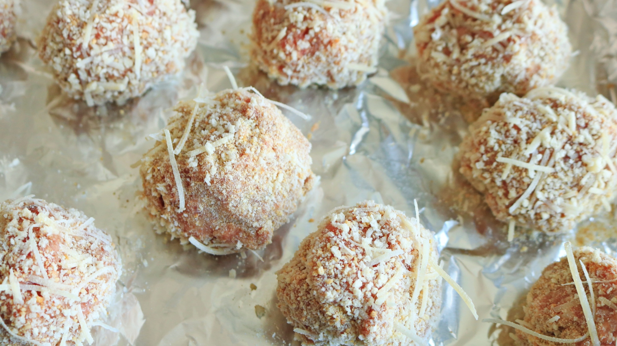 Breaded meatballs on a foil tray.