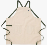 An off-white apron with green straps on a white background.