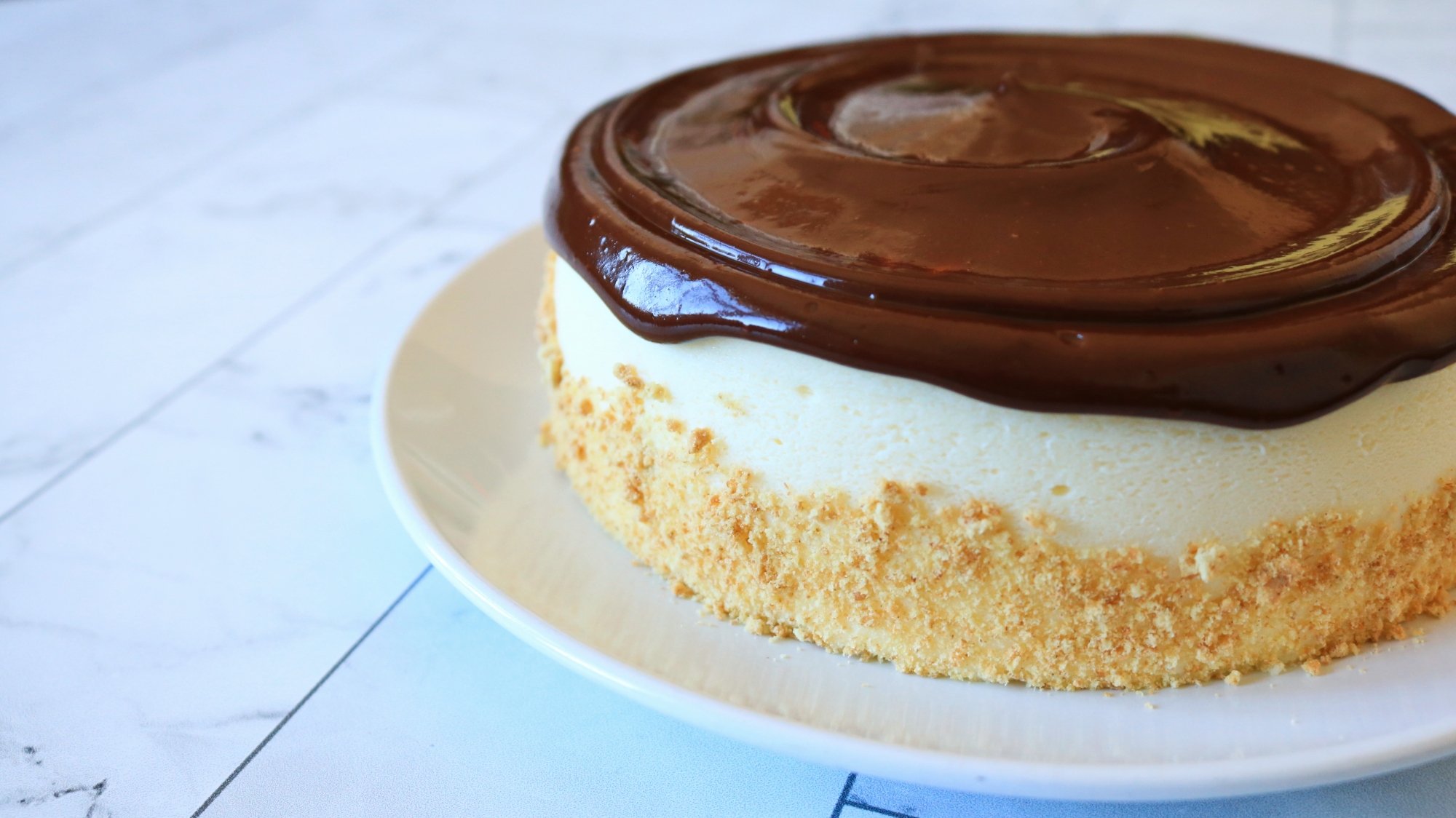 A cheesecake with chocolate ganache on top.